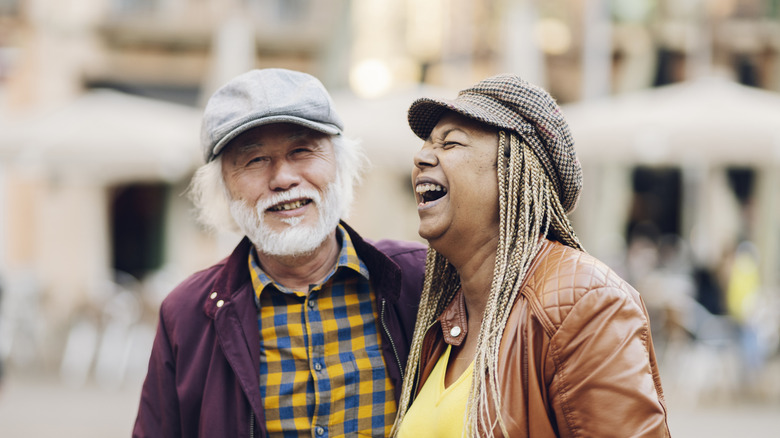 Senior couple smiling with a city street in the background