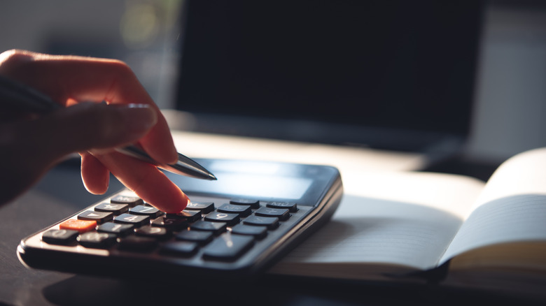 Close up of a hand using a calculator.