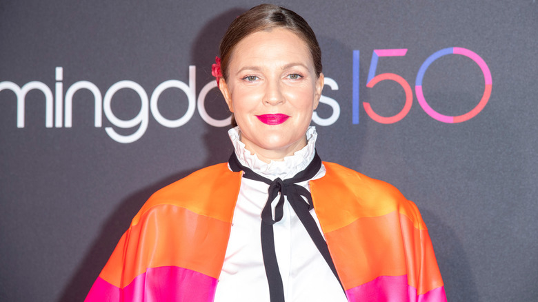 Drew Barrymore smiling at the camera at an event.