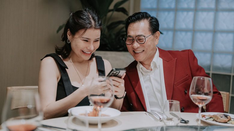 A wealthy couple smiling together at a nice restaurant