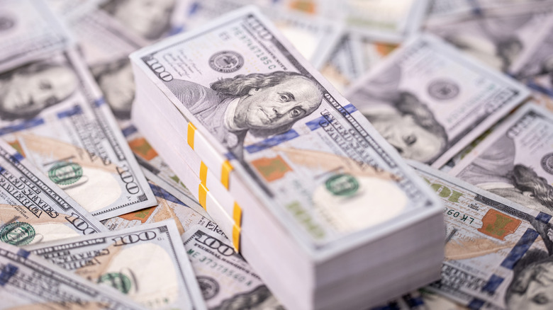 Bundles of $100 bills stacked in threes over single bills