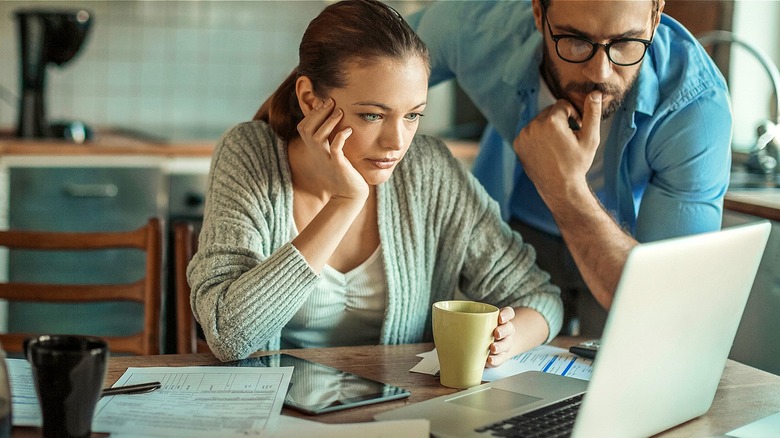 Couple looking at laptop concerned