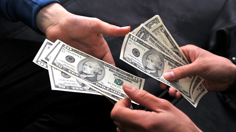 Hands exchange money