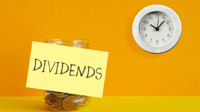 Jar of coins with the word dividends and a clock