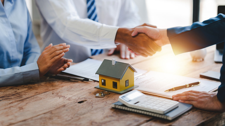 real estate agent shaking hands with customers