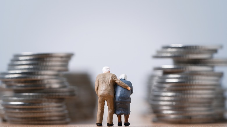 Miniature of a mature couple between stacksof coins
