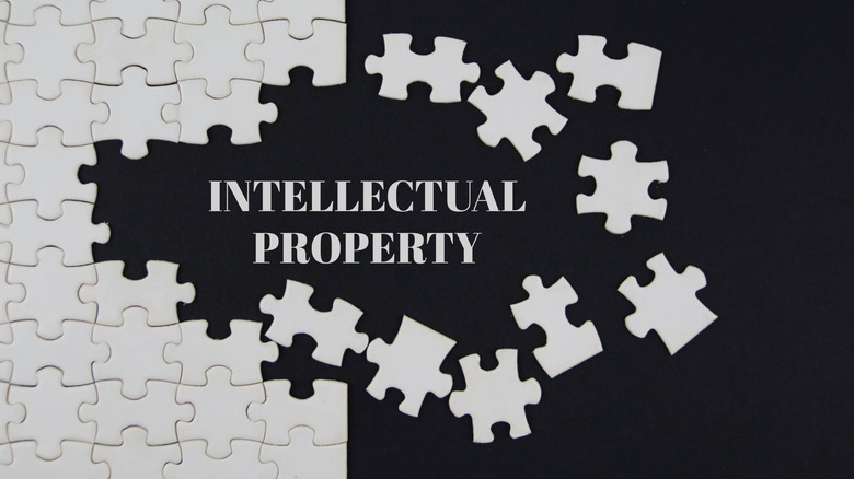 Words "Intellectual property" and white puzzle pieces on a black background