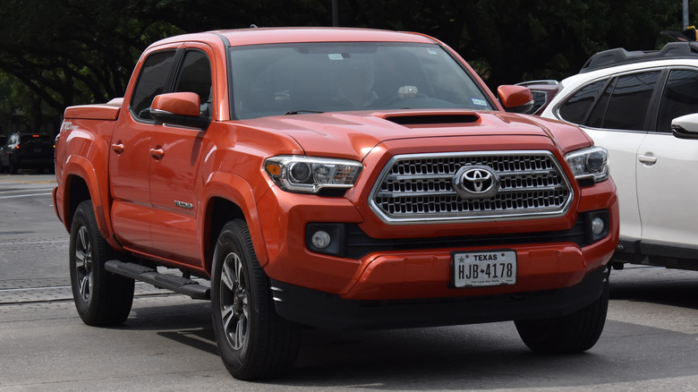 A red Toyota Tacoma cruising in near Hermann Park in Houston.
