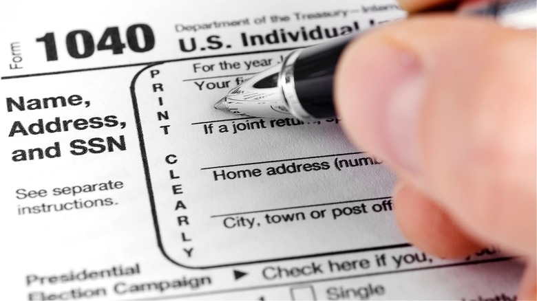 Person filling out 1040 Form