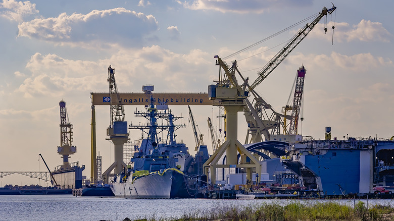 Warships under construction in a Mississippi harbor on a sunny, lightly cloudy day