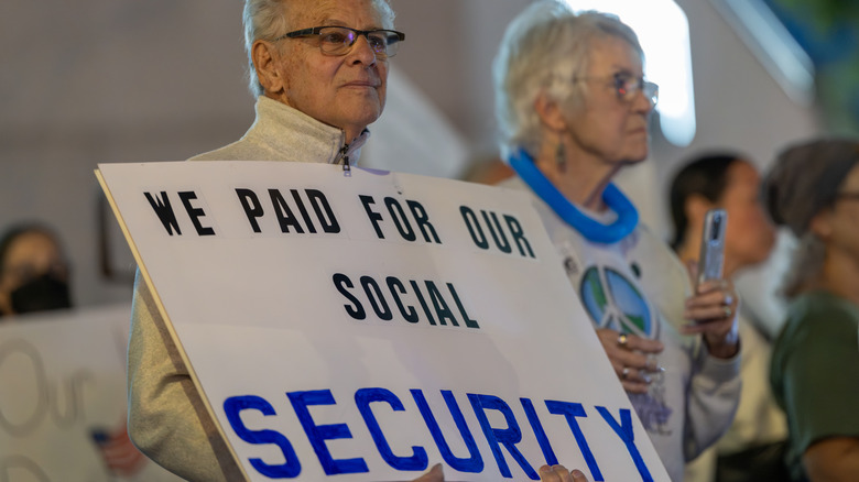 Older couple demonstrate against cuts to Social Security.