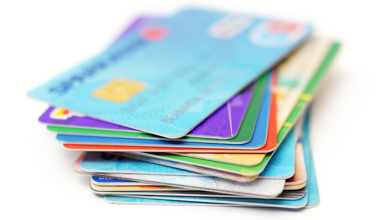 A stack of credit cards on a white table.