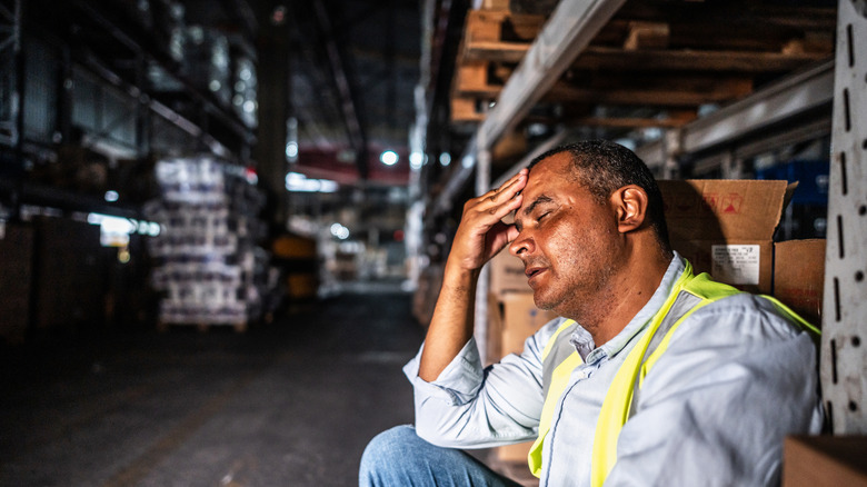 Discouraged looking man working in a warehouse