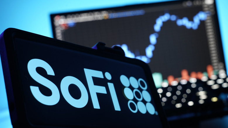 SoFi logo in phone and stock chart in background