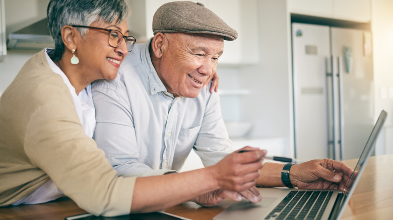 Older couple looking at a laptop together.