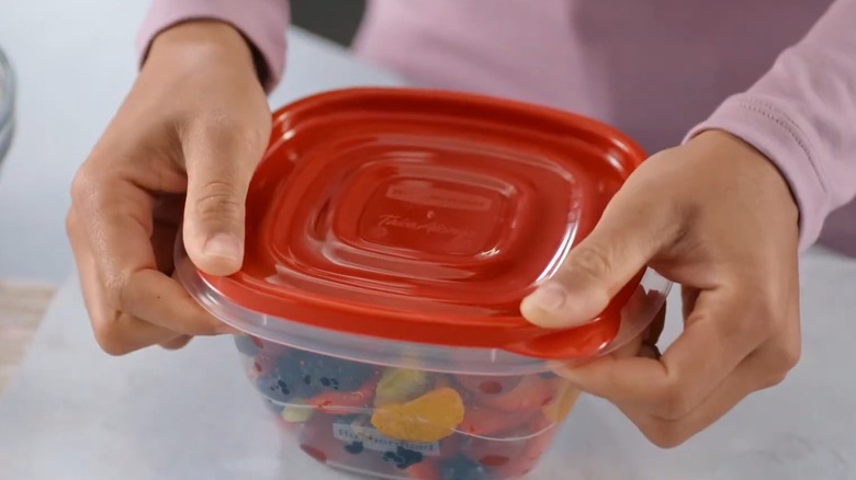 Woman putting a lid on a Rubbermaid container
