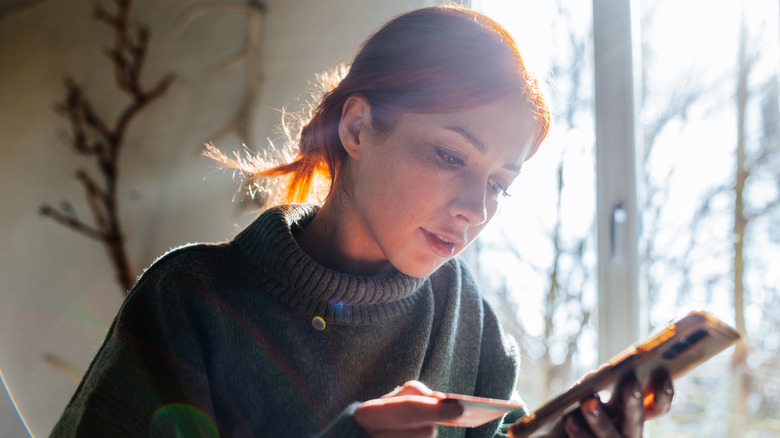Woman shopping online with laptop and credit card on hand.