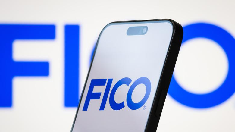 The logo of Fair Isaac Corporation (FICO) is displayed on a smartphone screen,