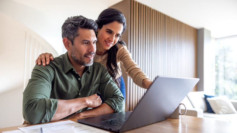 couple checking bank statements on their laptop
