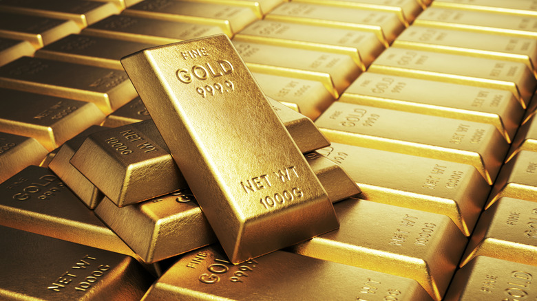 A pile of gold bars rest on rows of gold