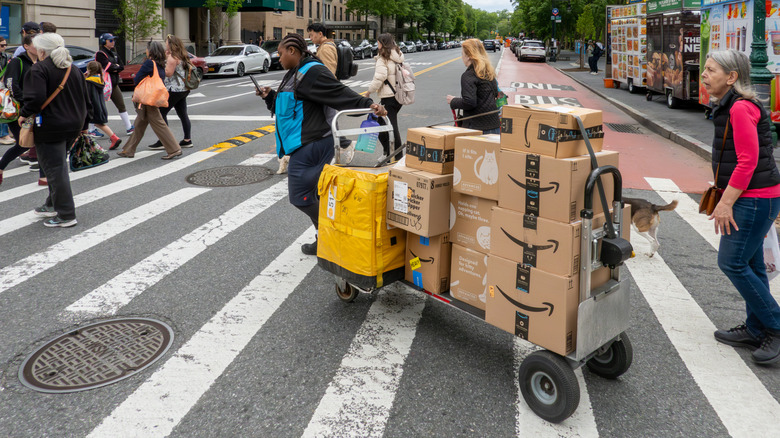 An Amazon employee pulls a cart filled with Amazon Prime packages in New York