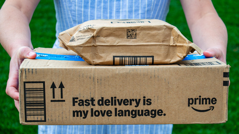 Person holding Amazon delivery boxes