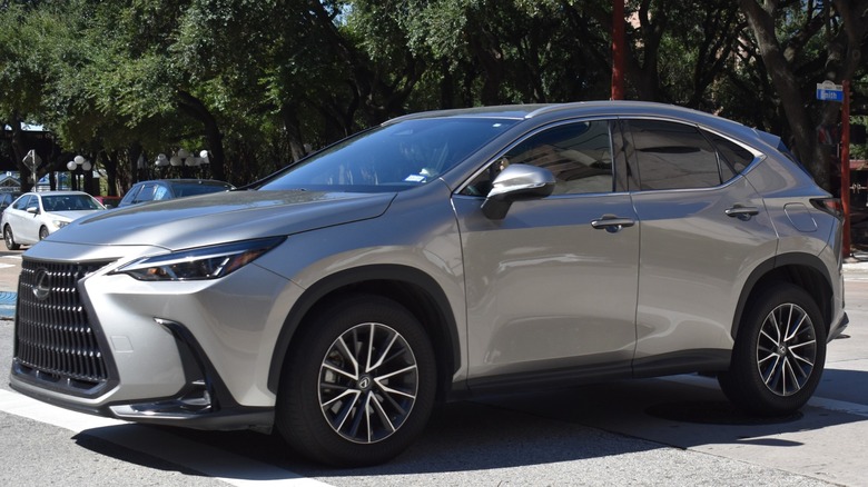 Silver Lexus UX SUV parked on a tree-lined street, viewed from the front-left side