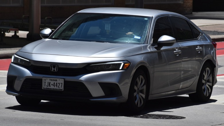 Gray Honda Civic LX driving down a road