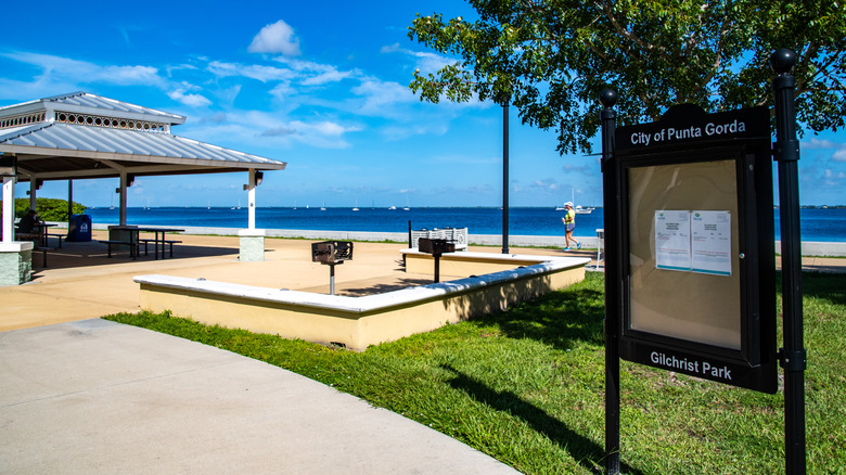 A waterfront park in Punta Gorda, Florida, with picnic tables and barbecue pits.
