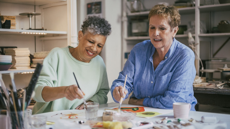 Two women painting together at table