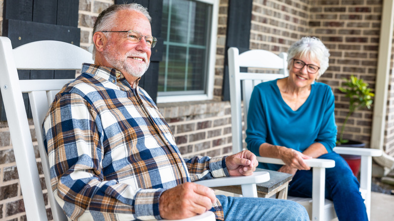 Senior couple sitting in rocking chairs on porch