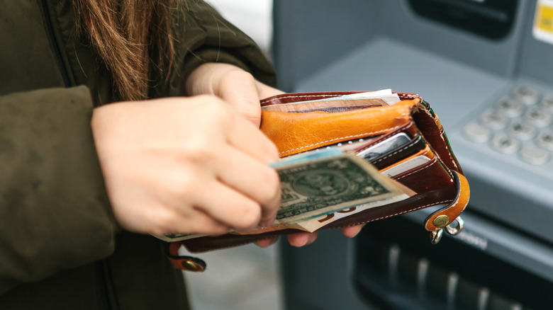 Woman holding wallet with money