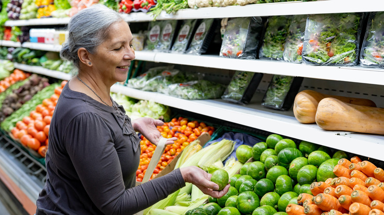 Woman with gray hair shopping for vegetables