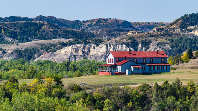 A large farmstyle home surrounded by nature and hills