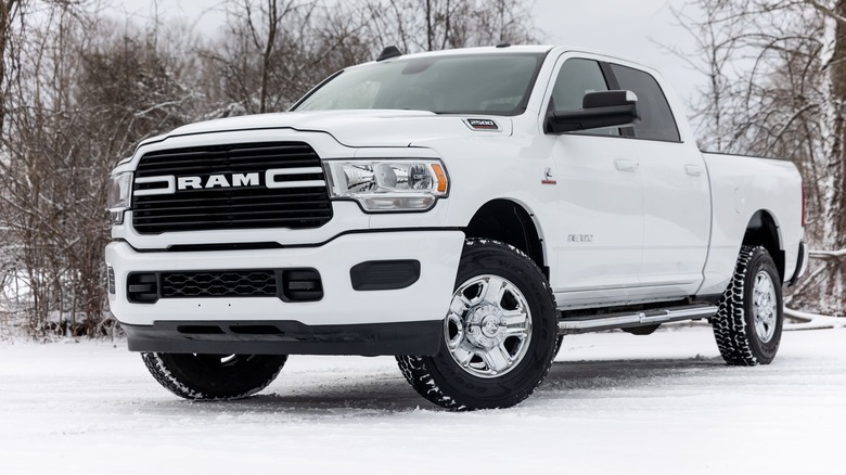 A white Ram 2500 pickup truck with lifted wheels in the snow