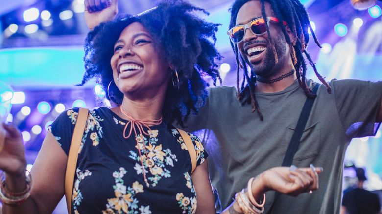 A smiling couple is dancing at a night club