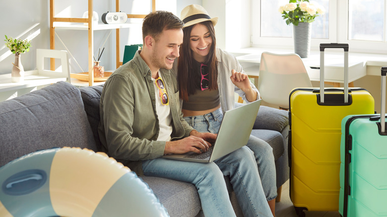 Happy tourist couple, young family online choosing trip