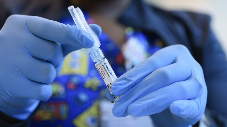 Immunization Nurse Ruth Jones holds a Pfizer-BioNTech COVID-19 vaccine