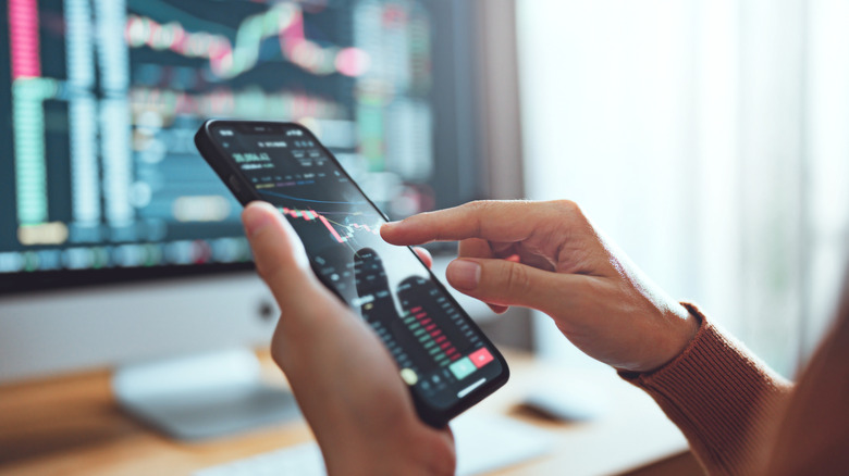 woman checking stock market prices on phone