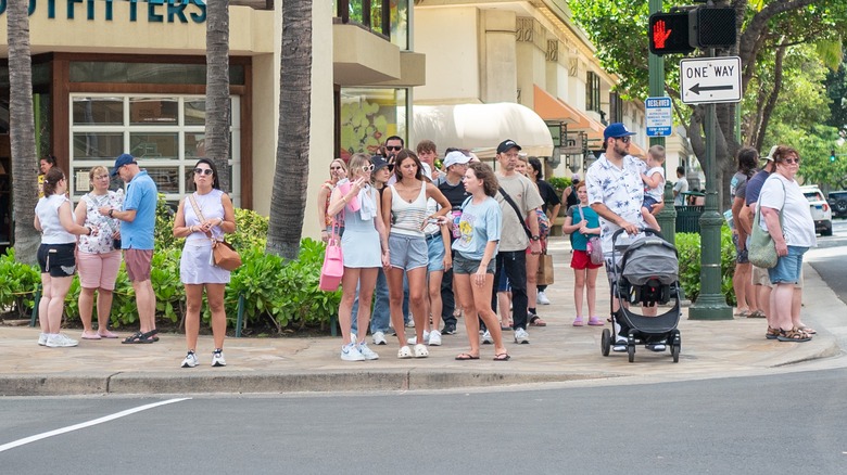 Large group of tourists preparing to cross a road in Waikiki, island of Oahu, Honolulu, Hawaii,