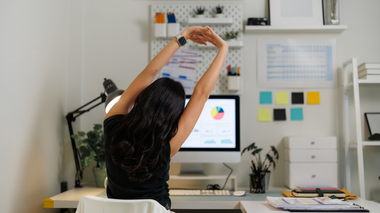 Woman stretching at work desk
