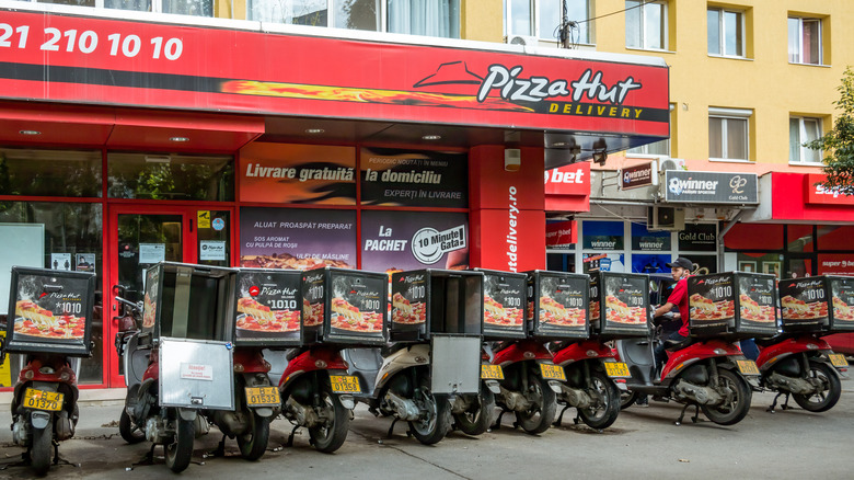 A selection of Pizza Hut delivery bikes outside a Pizza Hut location