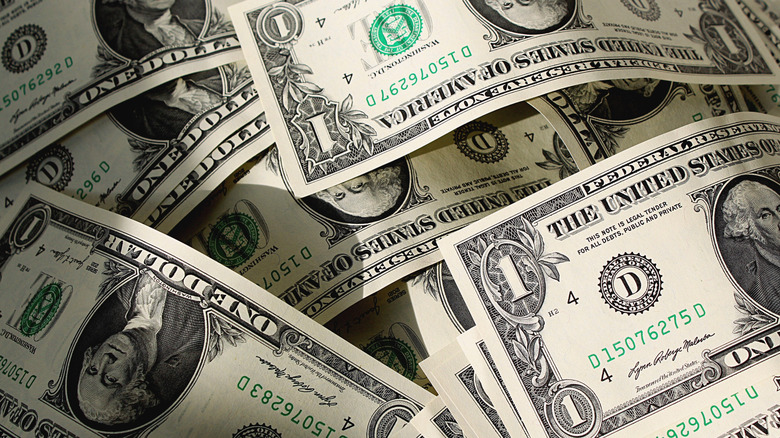 a large pile of dollar bills