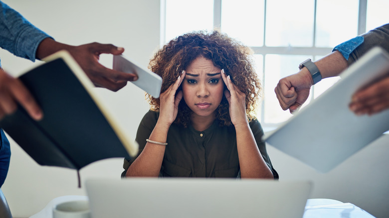 A young worker looking stressed out as their desk.