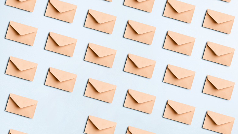 Directly above view of many beige envelopes on a blue colored background.
