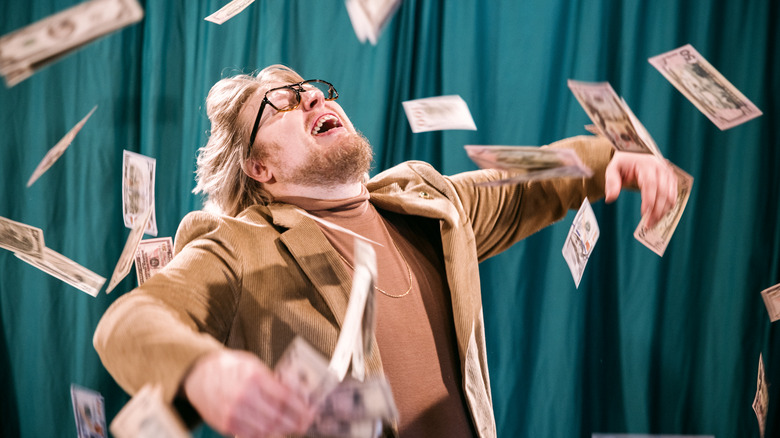 A overjoyed man being showered with money