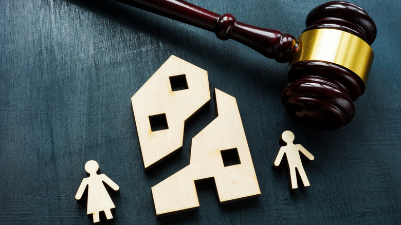 A toy house split in two with two toy people on either side