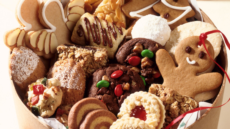 Holiday cookies including a gingerbread person are nestled into a cardboard box.