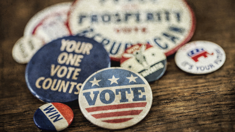 Antique looking political pins on a table.