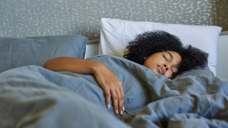 woman lies asleep in bed